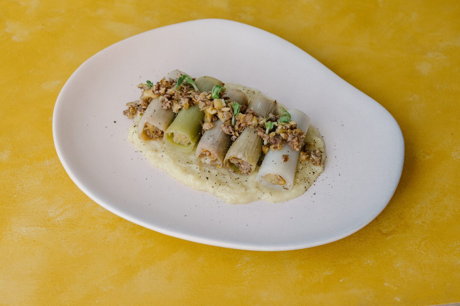 Prei cannelloni gevuld met oesterzwam en walnoten op knolselderijcrème