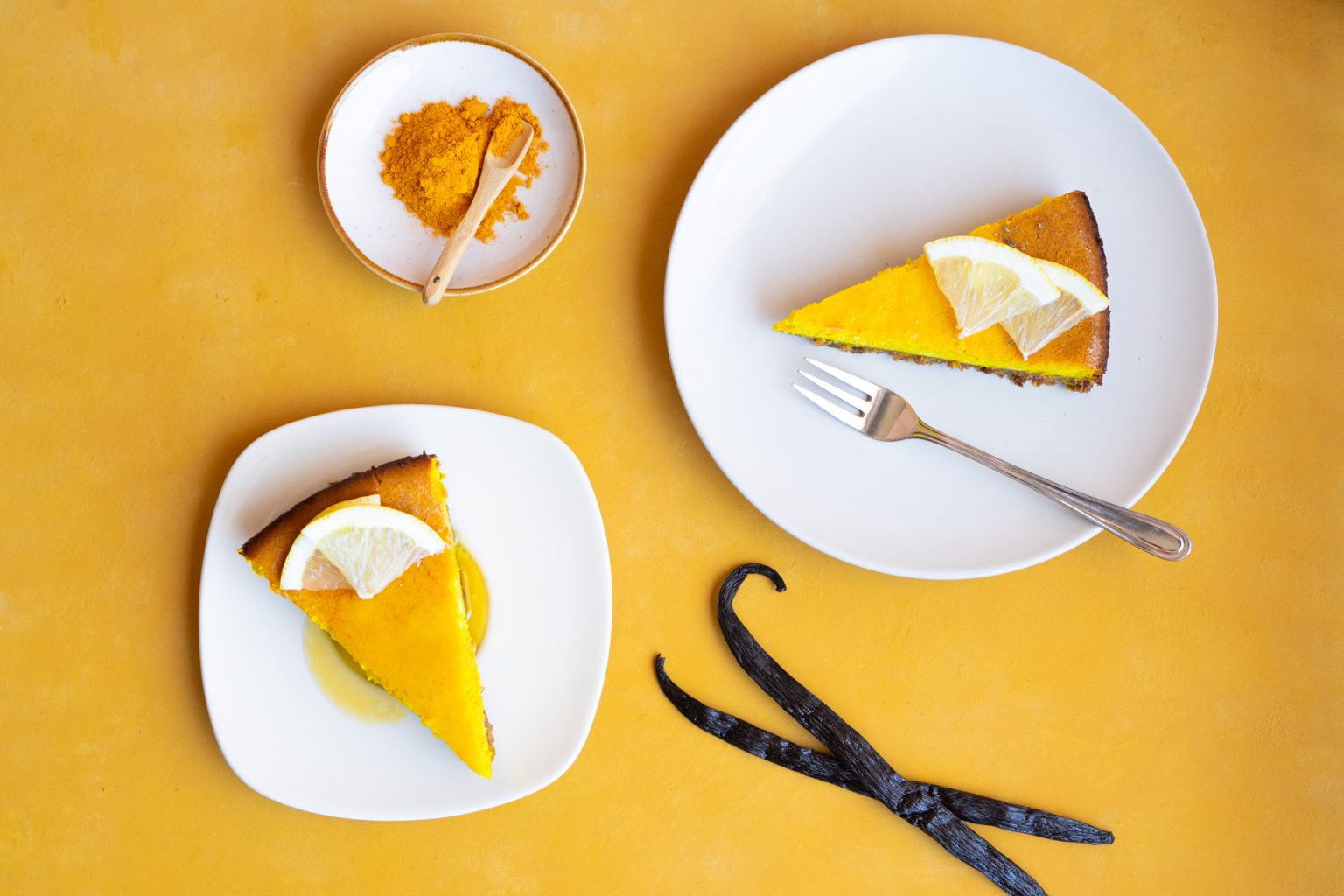 Romige kurkuma-citroen cheesecake met witte chocolade, frisse citroen en een goudgele kleur door pure kurkuma